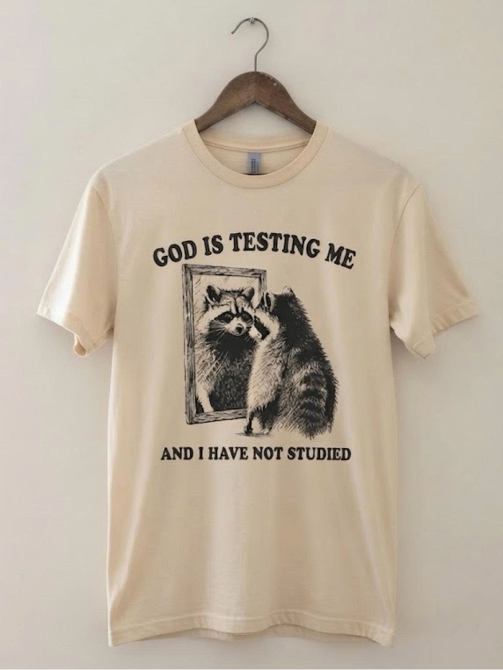 Gildan Cream Graphic Raccoon Tee - 'God Is Testing Me' | Unisex Shirt